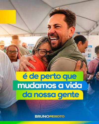 Bruno abraçando moradora em evento da comunidade